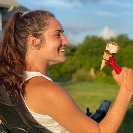 Teenage girl holding an ice cream cone with the functionalhand® enjoying a summer treat.