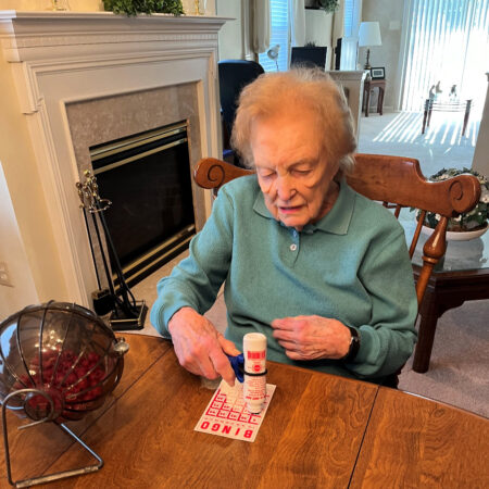 A woman with hand arthritis plays bingo using the functionalhand®