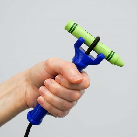 An image of a royal blue functionalhand® holding a bright green crayon, showing the elastic cord gripping the crayon and a natural hand position.