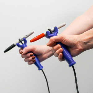 Two hands each holding a FUNctionalhand adaptive aid.