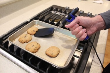 Senior adult using functionalhand in the kitchen to bake cookies