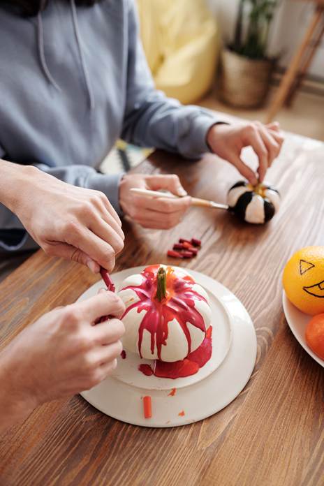 Inclusive Halloween activity for senior. Painting pumpking with paintbrush