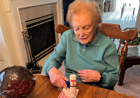 A woman with hand arthritis plays bingo using the functionalhand®